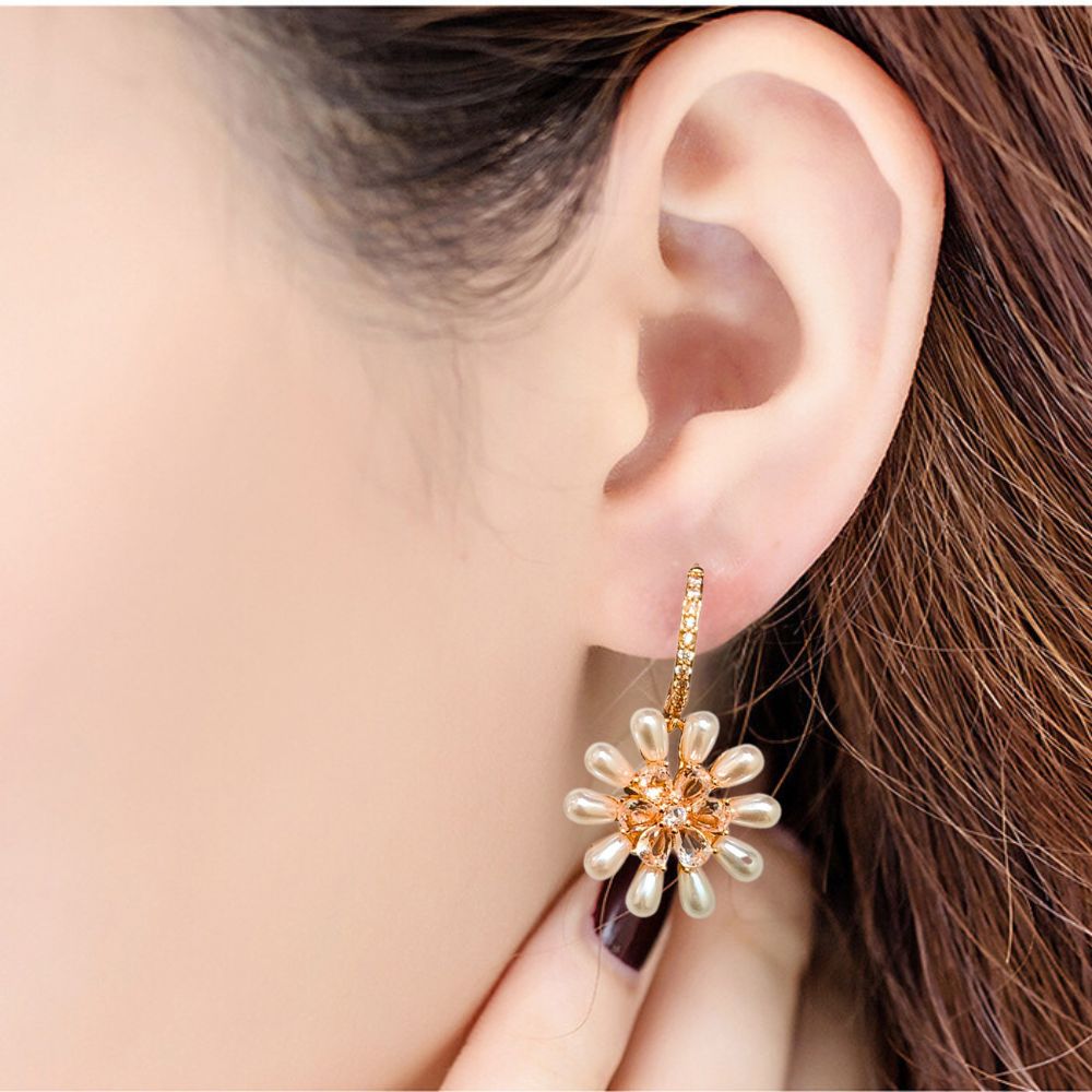 Gold-plated daisy drop earrings with pearl petals and crystal centers, perfect for weddings, brunches, or stylish everyday looks.