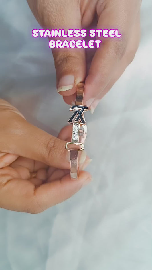 Close-up of a rose gold bracelet featuring a sleek key and initial design, with sparkling accents, perfect for stylish women.