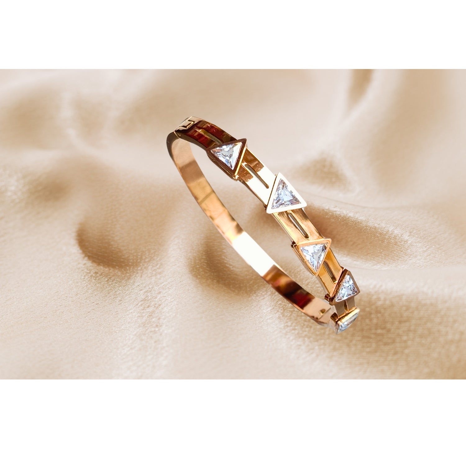 Rose gold bracelet with triangle-cut cubic zirconia stones, minimalist geometric design, perfect for stacking or wearing solo, modern chic jewelry accessory.